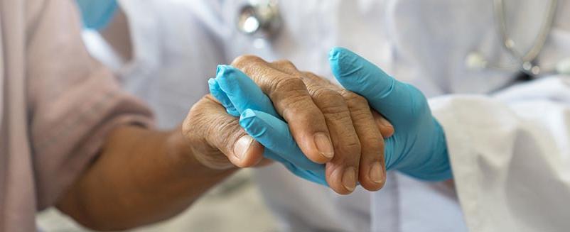 Medical professional holding hands with patient