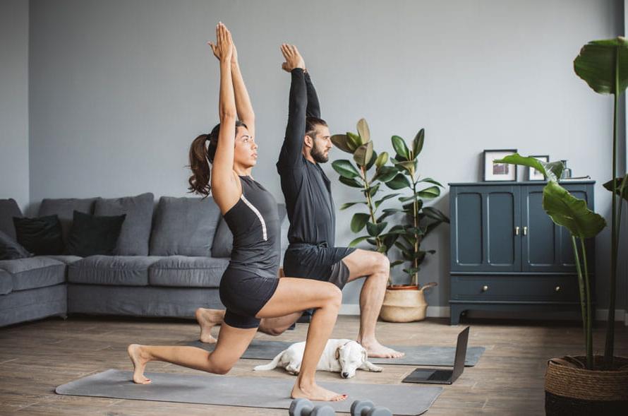 Young couple at home practicing yoga.