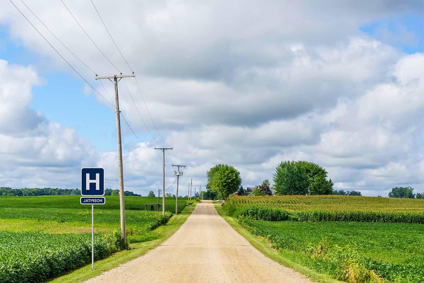 Image of a country road with road sign saying "Hospital"
