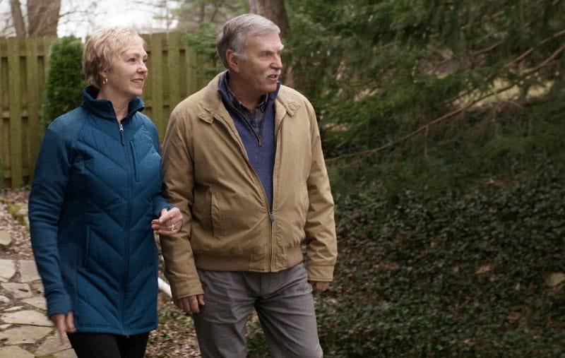 Gail Hogan and her husband walk outdoors