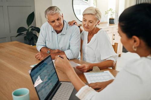 Older couple sitting with financial planner at a table